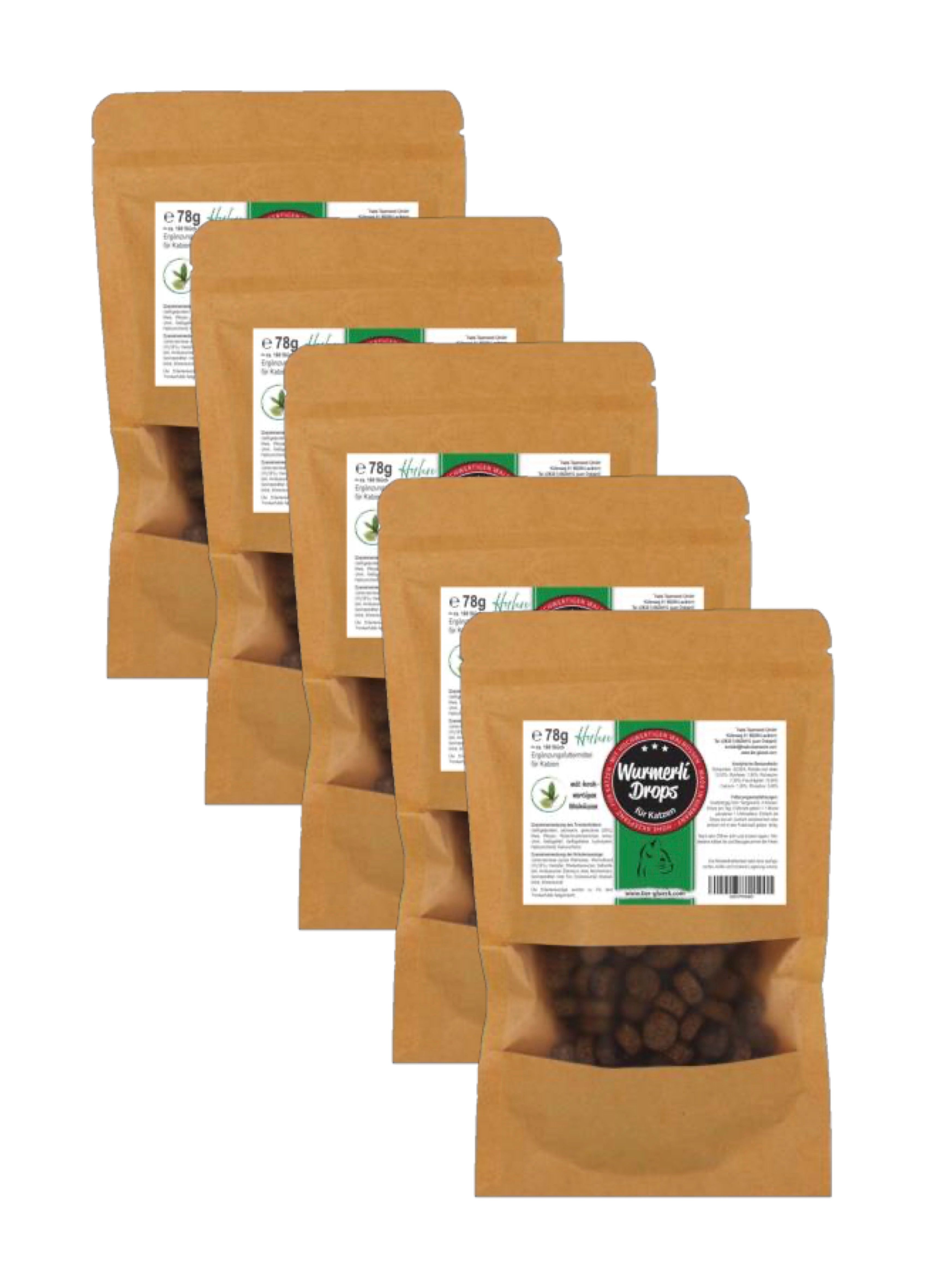 Fünf Beutel TierGlück Wurmerli Drops. Braune Papierbeutel mit Sichtfenster, gefüllt mit braunen Drops. Aufdruck mit Produktinformationen.