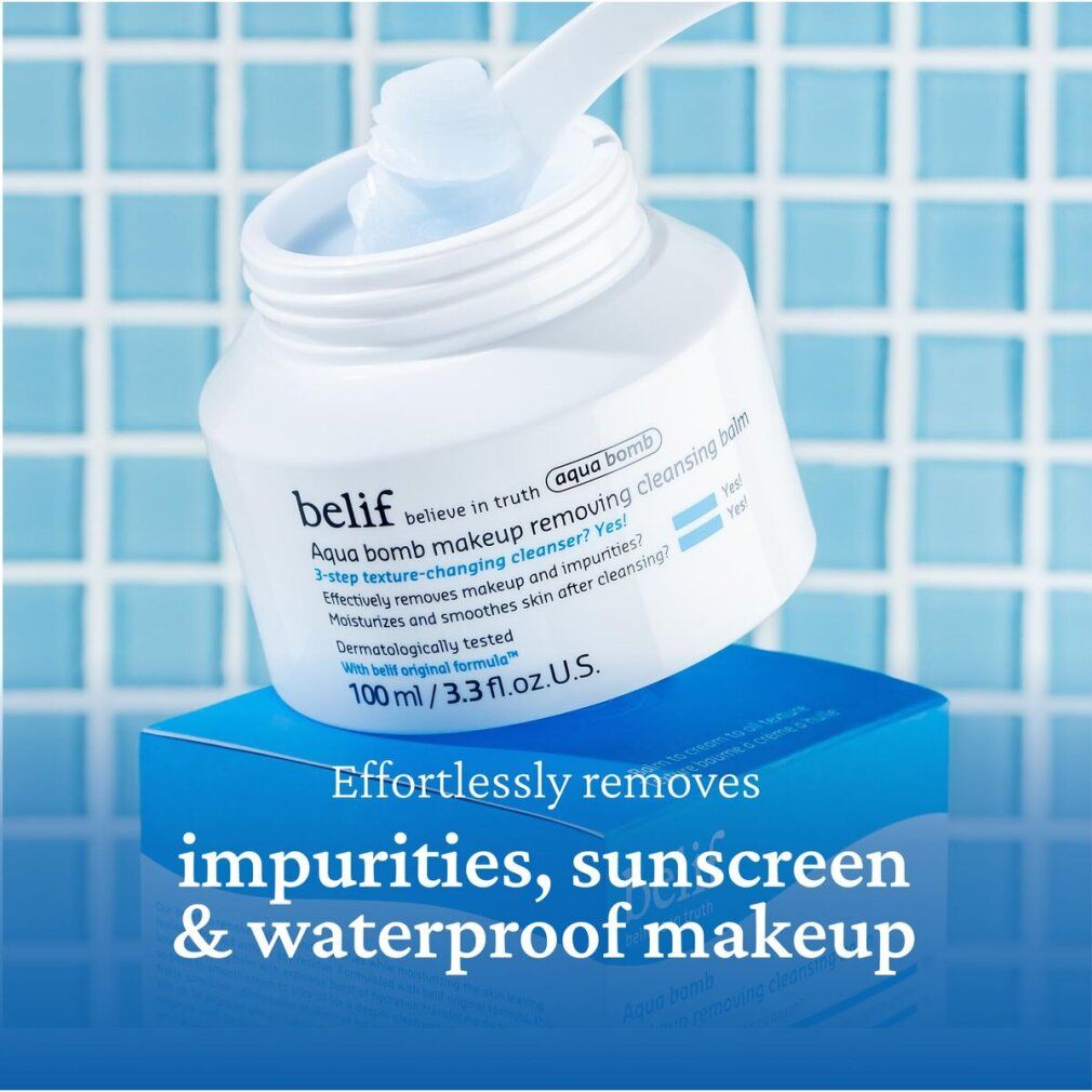 Weißer Tiegel mit blauem Balsam. Aufschrift: Aqua bomb makeup removing cleansing balm. Auf blauem Untergrund. Mit Spatel.