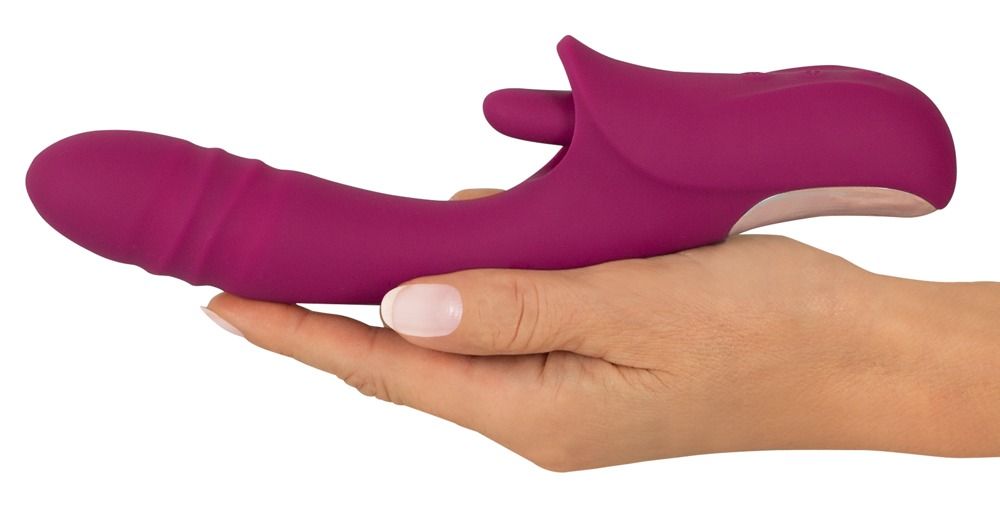 Magenta Vibrator in einer Hand gehalten. Die Hand zeigt eine helle Hautfarbe.