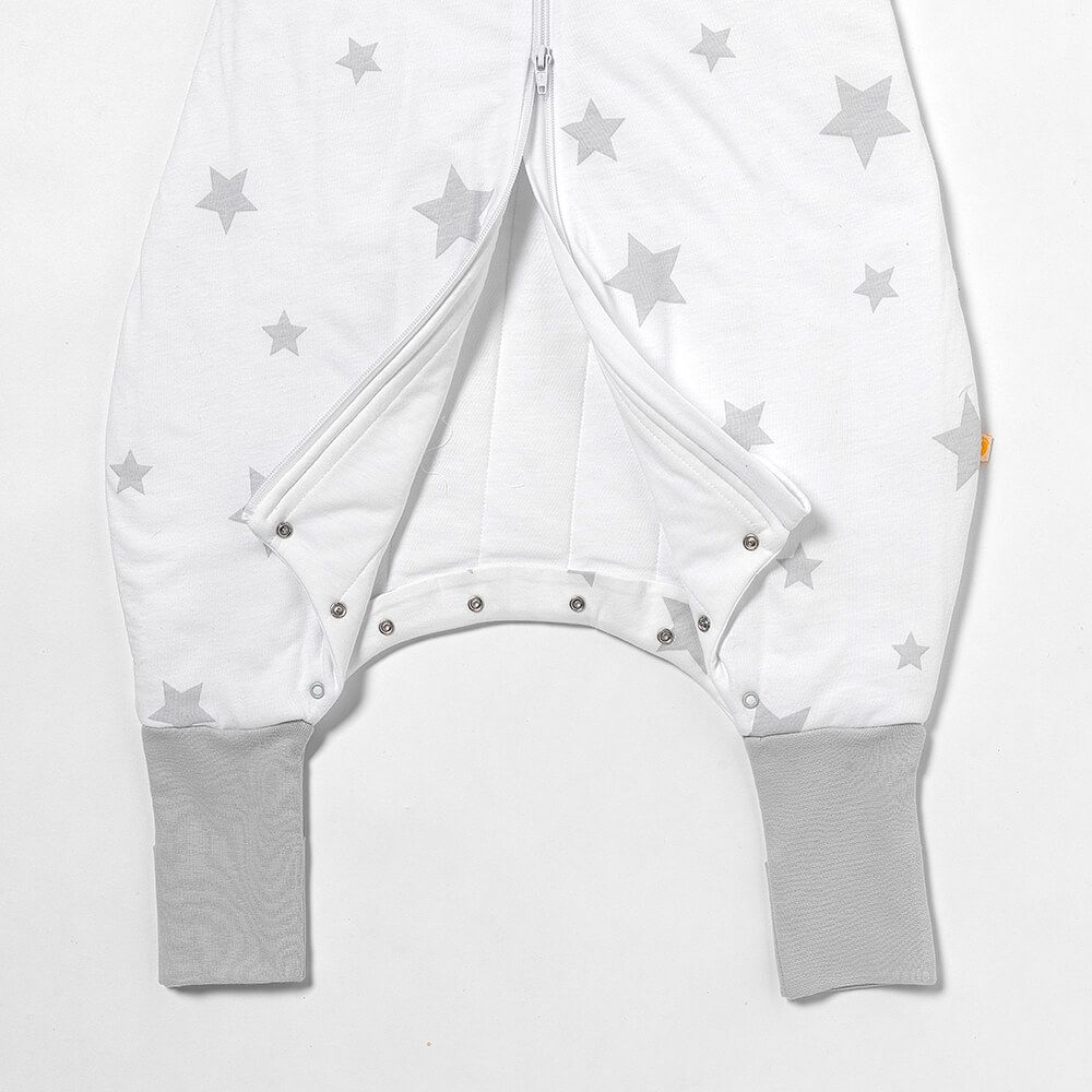 Baby-Schlafsack mit Füßen, grau Sterne. Reißverschluss geöffnet, Druckknöpfe sichtbar.