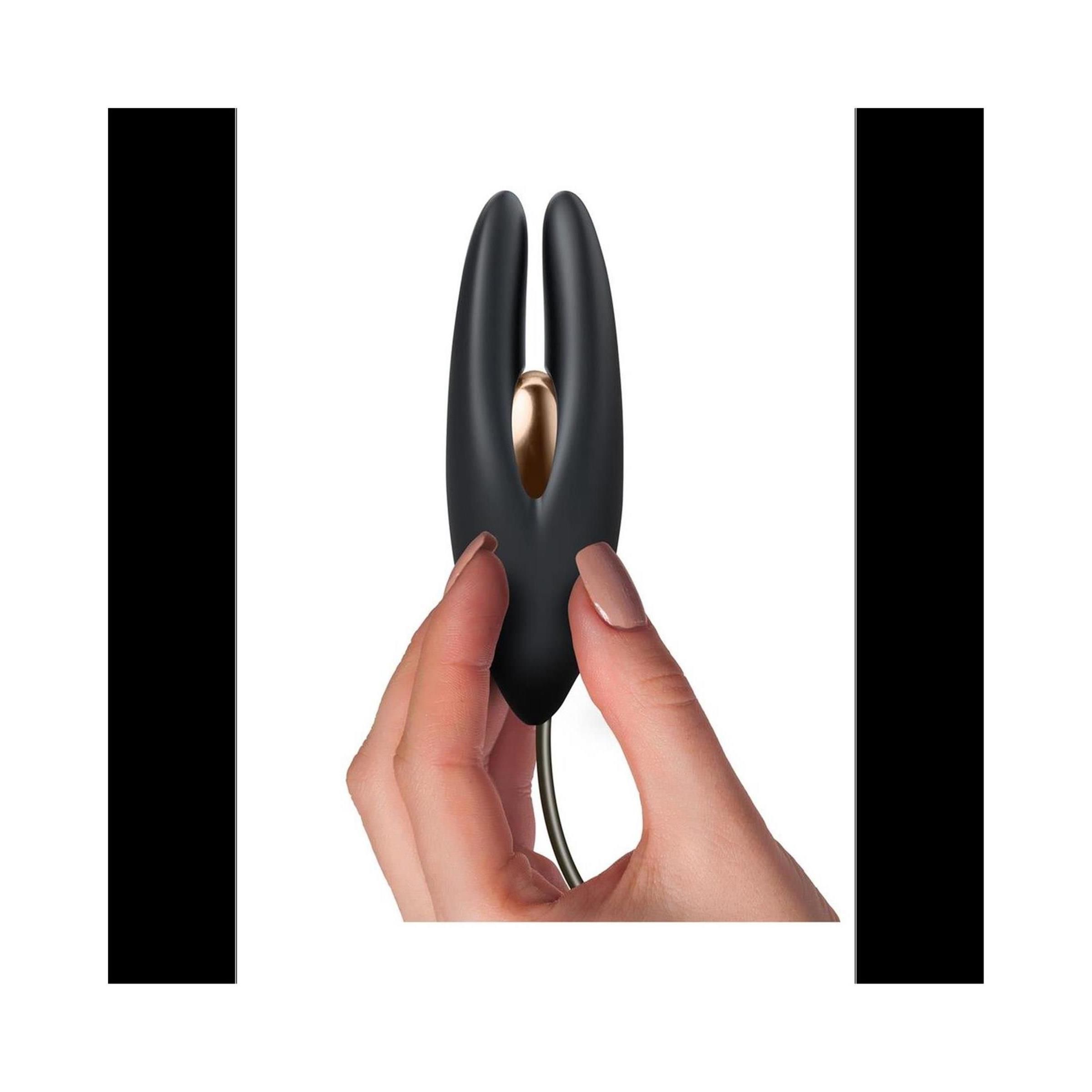 Hand hält schwarzes Produkt mit goldfarbenem Element. Kabelanschluss.
