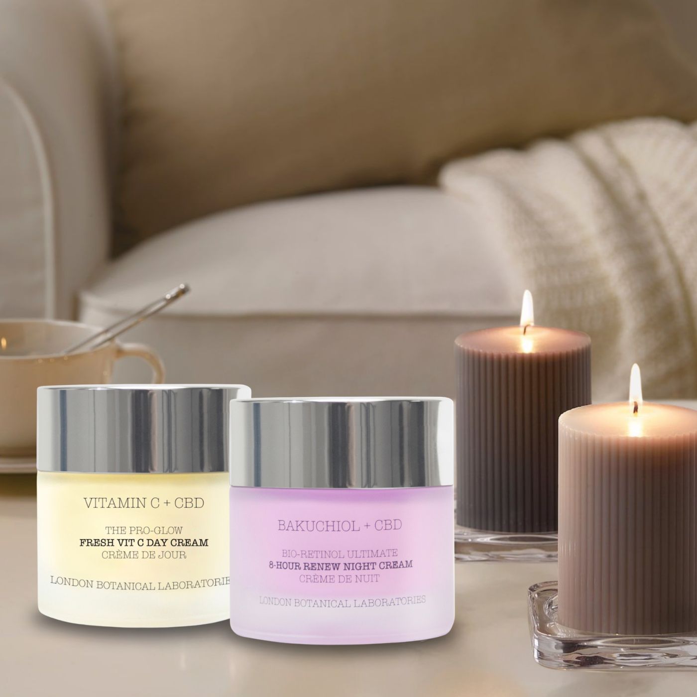 Zwei Tiegel Tages- und Nachtcreme neben brennenden Kerzen. Aufschrift: Vitamin C + CBD, Fresh Vit C Day Cream, London Botanical Laboratories. Bakuchiol + CBD, 8-Hour Renew Night Cream.