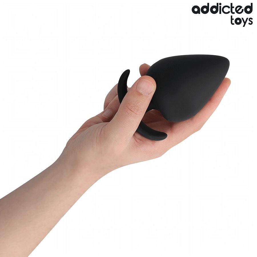 Schwarzer Analplug in einer Hand gehalten. Tropfenförmiger Kopf, gebogene Basis. Marke: Addicted Toys.