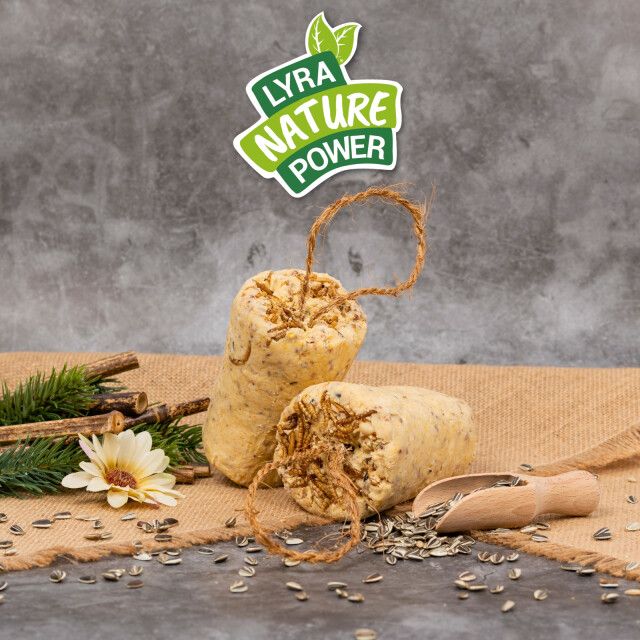 Zwei Körnerriegel mit Mehlwürmern auf Jutestoff. Logo: LYRA NATURE POWER. Zubehör: Holzschaufel, Zweige, Sonnenblumenkerne.