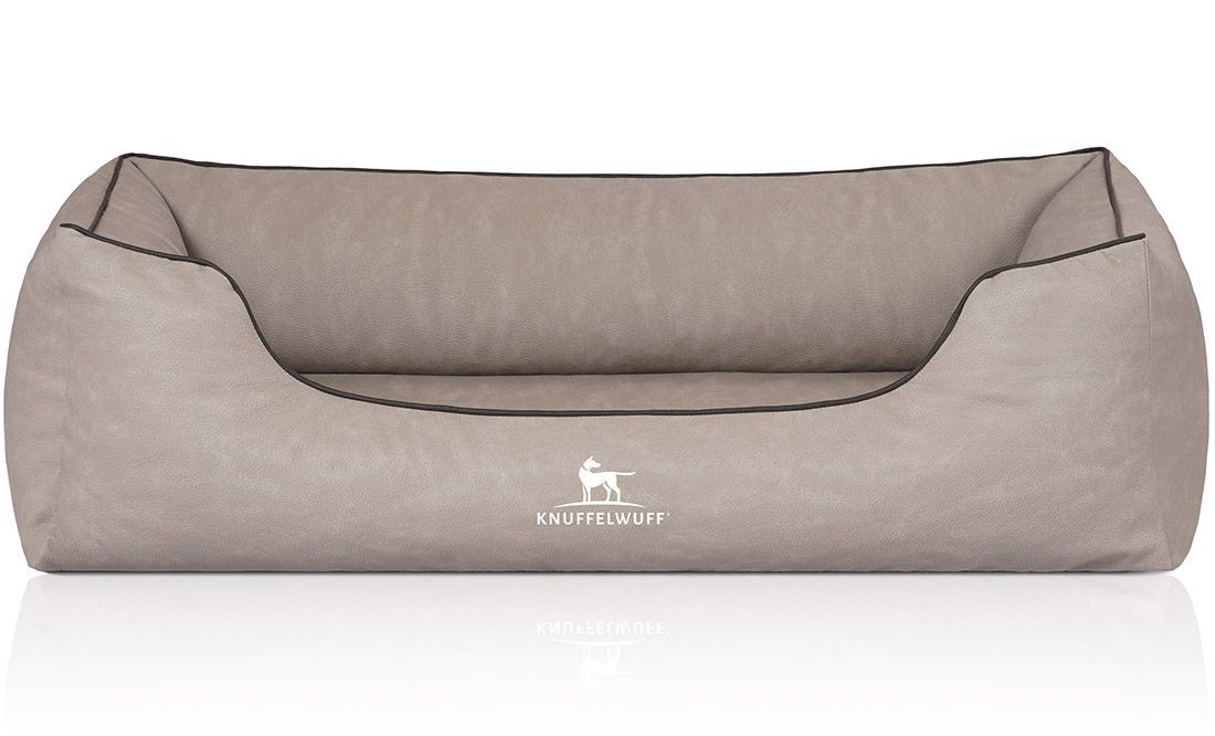 Beiges orthopädisches Hundebett mit schwarzer Umrandung. Logo: Hund mit Text Knuffelwuff. Rechteckige Form mit erhöhten Seiten.