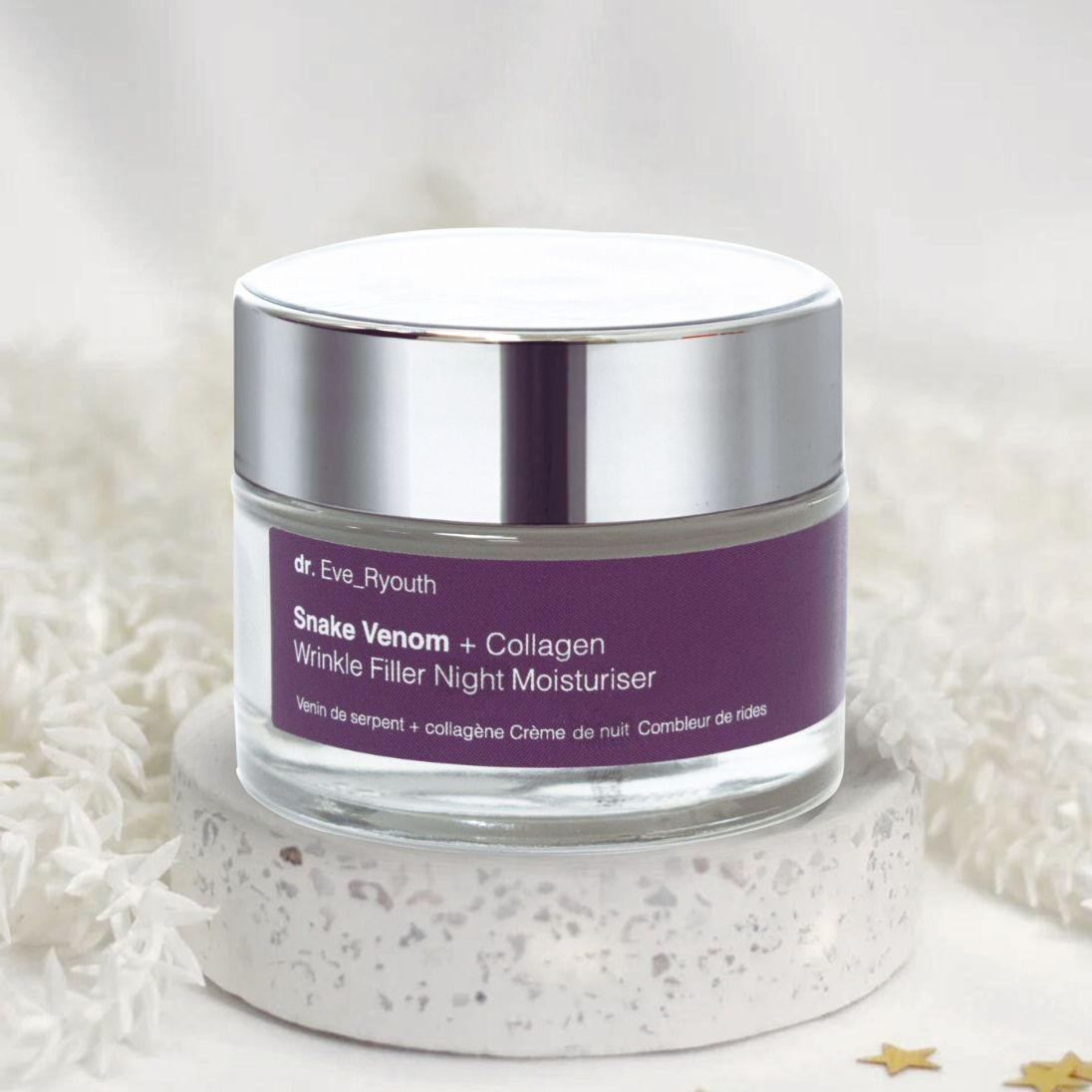 Glasbehälter mit silbernem Deckel und lila Etikett. Auf weißem Podest. Text: Snake Venom + Collagen Wrinkle Filler Night Moisturiser.