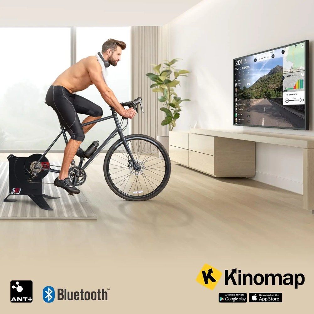 Mann fährt Rad auf Rollentrainer SBT1 vor großem Bildschirm. ANT+, Bluetooth.