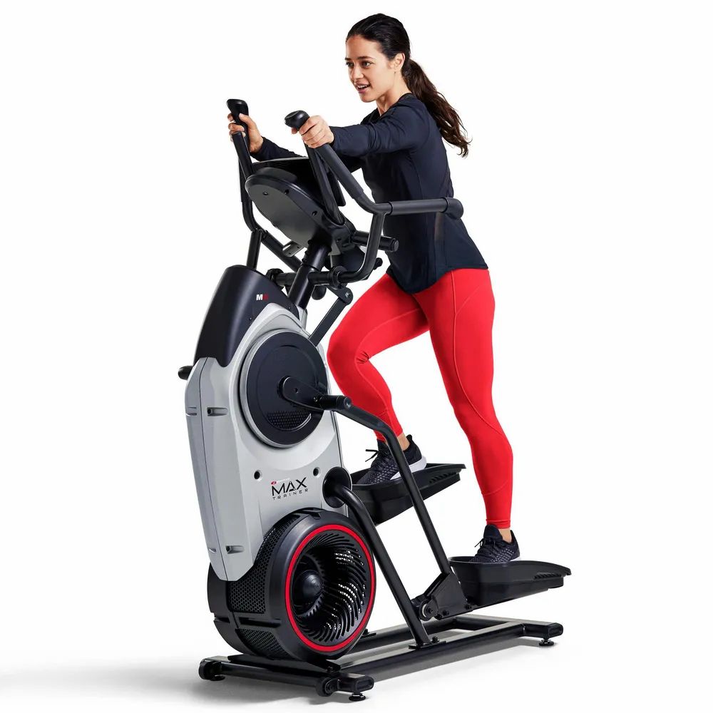 Femme s'entraînant sur un elliptique. Pantalon rouge. MAX Trainer M6i.