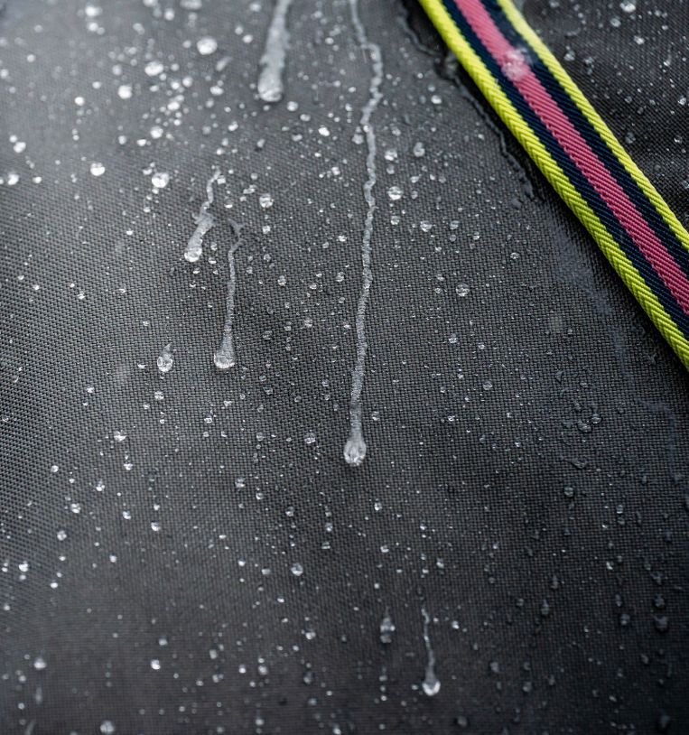 Graue Pferdedecke mit Wassertropfen. Nahaufnahme.