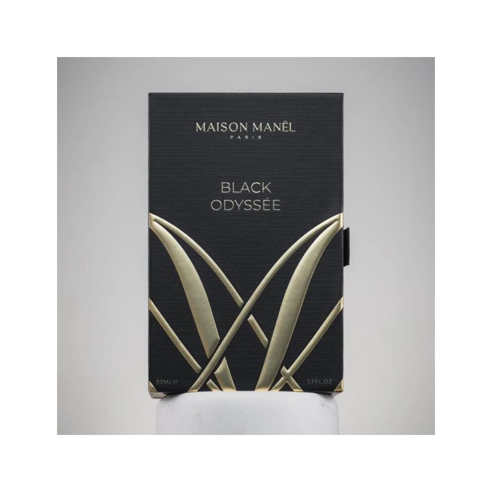 Schwarze rechteckige Verpackung. Goldfarbener Schriftzug: Maison Manel Paris, Black Odyssée. Geprägtes Logo.