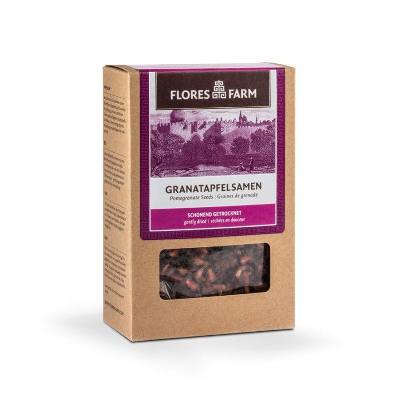 Kartonverpackung mit Granatapfelsamen. Sichtfenster zeigt getrocknete Samen. Aufschrift: Flores Farm, Granatapfelsamen, schonend getrocknet.