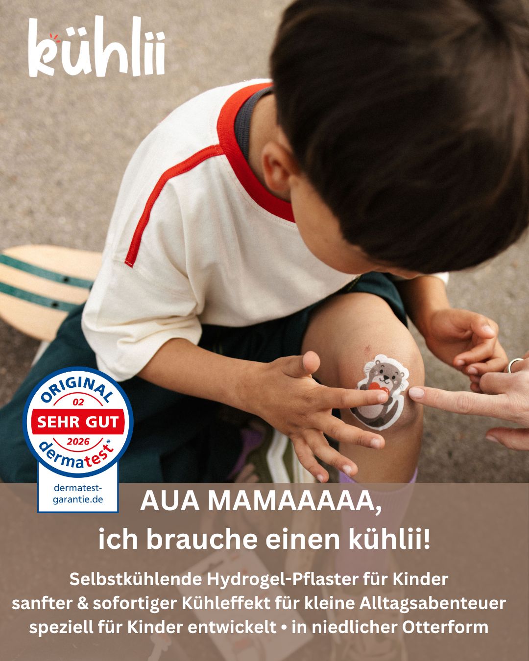 Kind mit Kühlpflaster mit Otter-Motiv auf dem Knie, sitzt auf Skateboard.