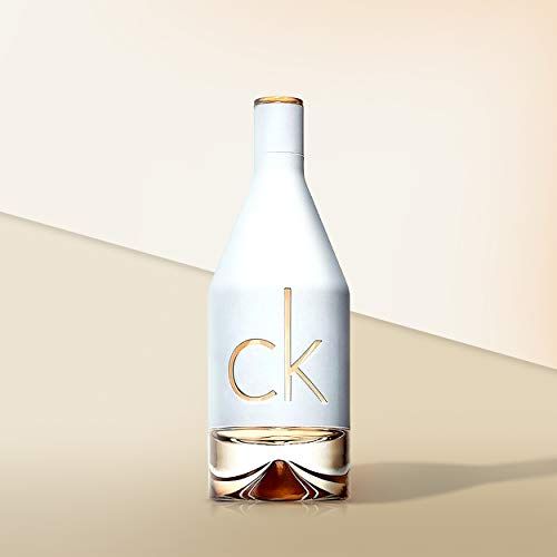 Weiße Parfümflasche mit goldenem 'ck'-Logo und klarem Bodenteil.