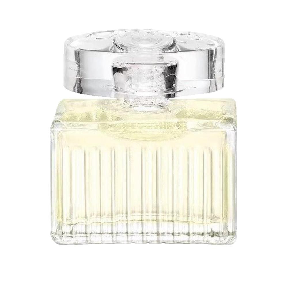 Quadratischer Glasflakon mit geriffelter Vorderseite. Transparenter Deckel. Flüssigkeit hellgelb. 
