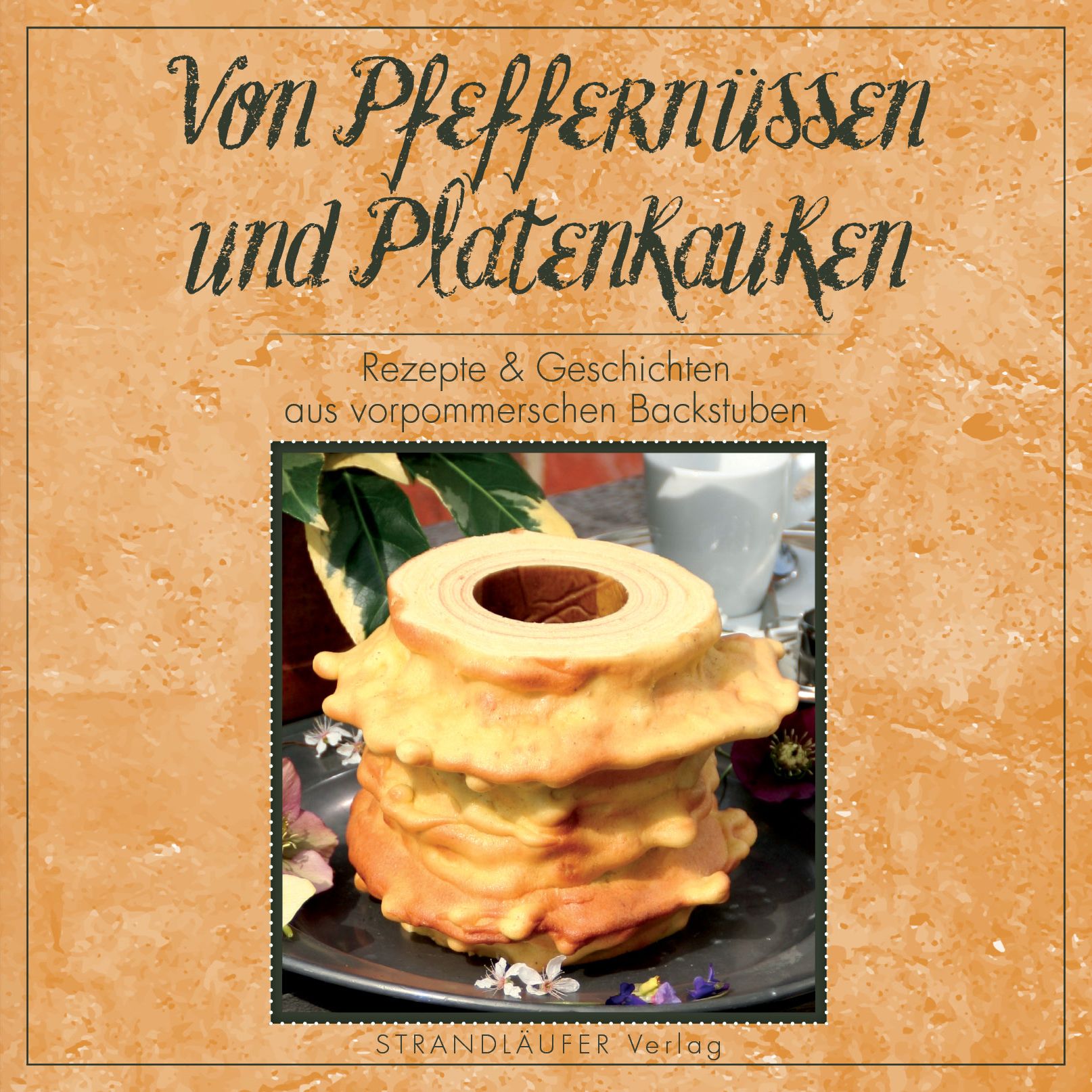 Buchcover mit Titel "Von Pfeffernüssen und Platenkauken". Rezept- und Geschichtenbuch, Baumkuchen auf Teller.