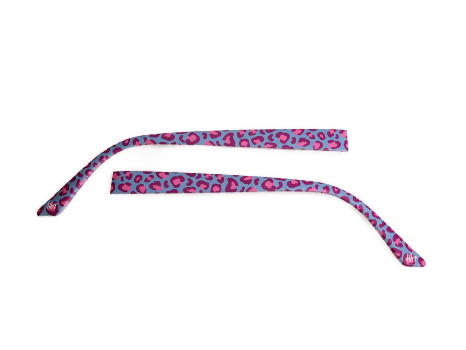 Zwei Brillenbügel mit Leopardenmuster in Lila und Pink. Die Bügel sind gebogen und liegen auf weißem Hintergrund.