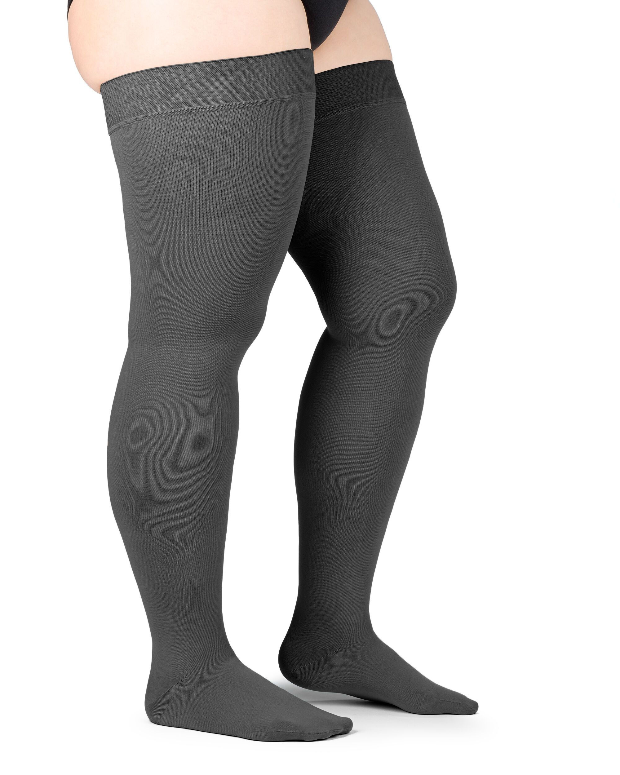 Zwei graue Kompressions-Schenkelstrümpfe. Sichtbar sind die Strümpfe bis zum Oberschenkel. Haftband am oberen Rand.