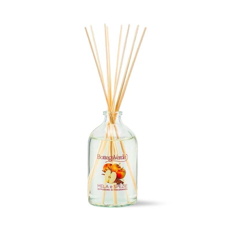 Diffusore di fragranza Bottega Verde Mela e Spezie. Bottiglia di vetro trasparente con liquido e bastoncini di legno. L'etichetta mostra mele e la scritta "Mela e Spezie".