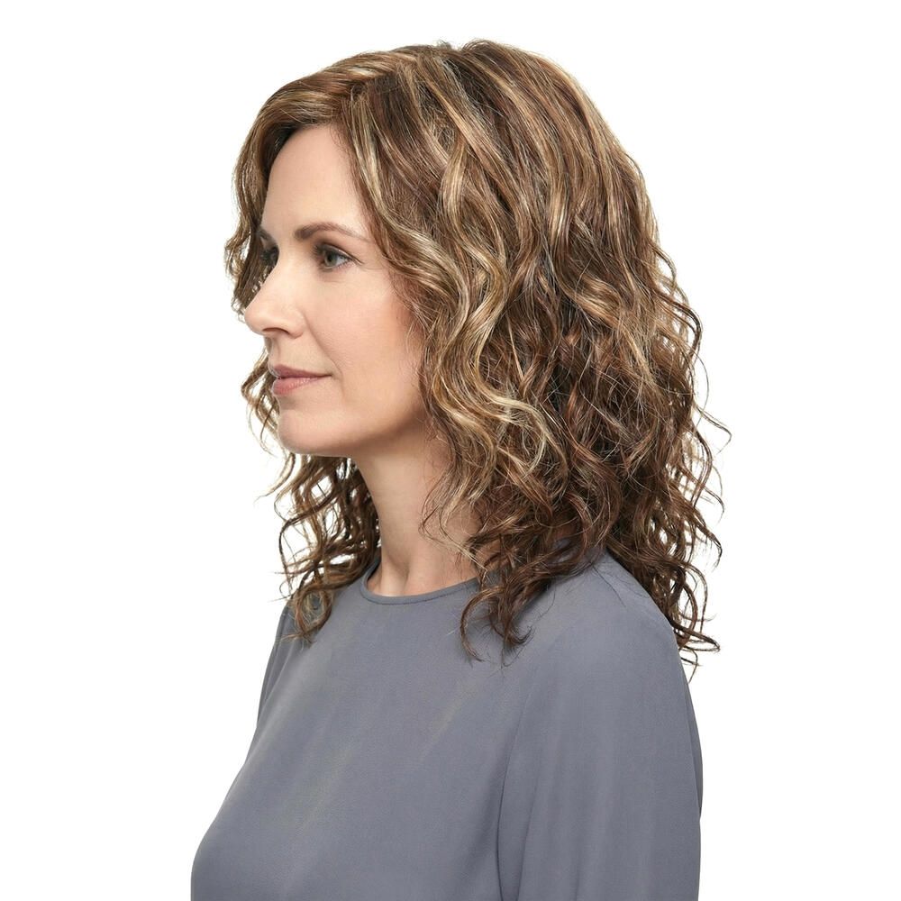 Perücke mit gewellten, braunen und blonden Haaren. Die Frau trägt ein graues Oberteil. Seitenansicht.