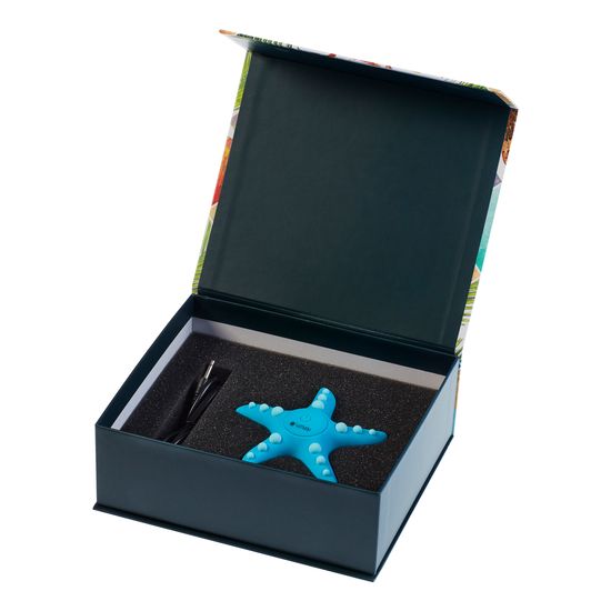 Auflegevibrator in Seesternform in einer geöffneten Geschenkbox. Enthält auch eine Pinzette.