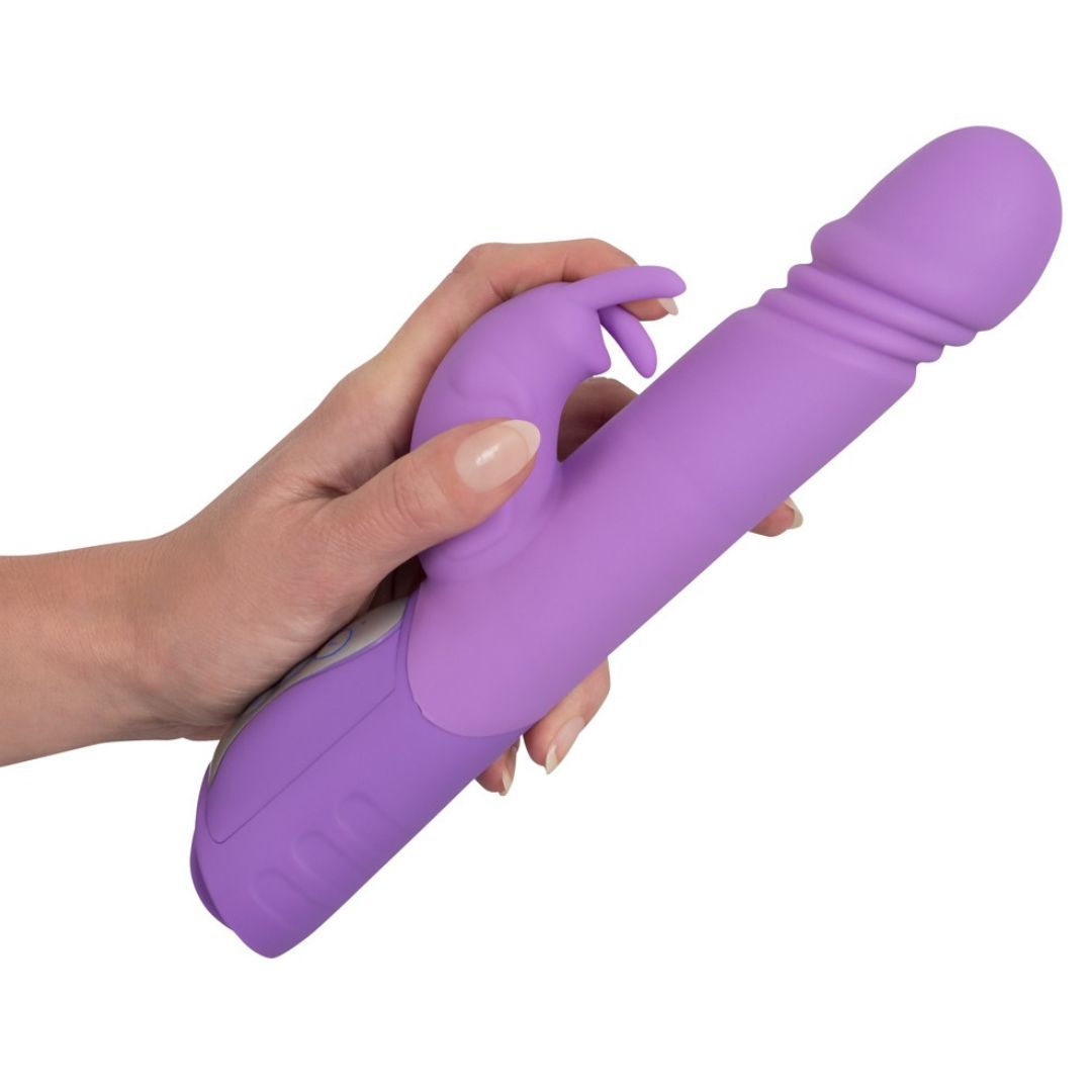 Lila Vibrator mit Stoßfunktion, in einer Hand gehalten. Deutlich sichtbar sind die Hasenohren.