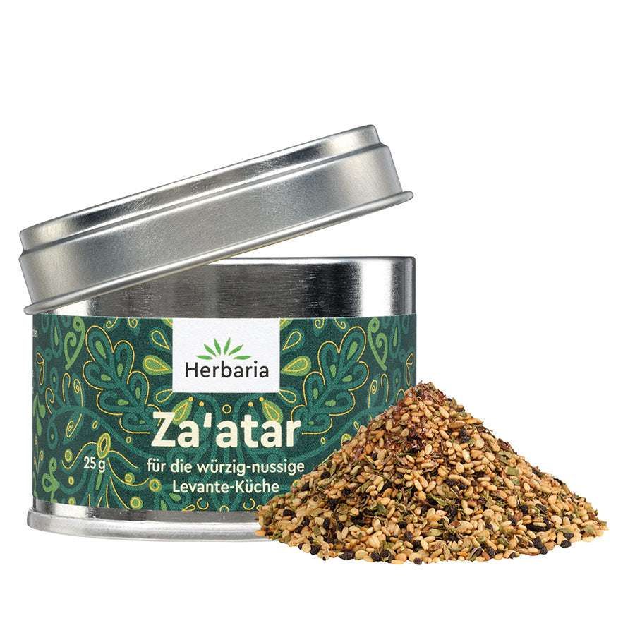 Zylindrische Dose mit Deckel, Za'atar-Gewürzmischung und Haufen. Dose mit grünem Muster und Aufschrift "Herbaria Za'atar".