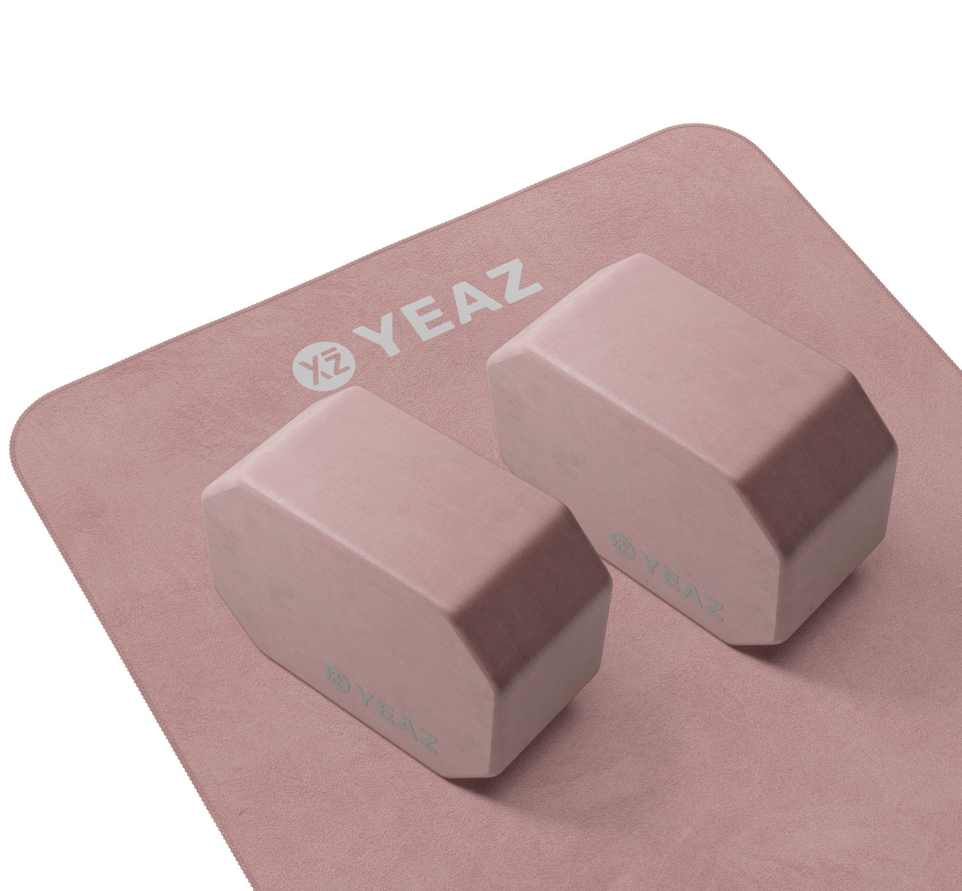 Zwei rosafarbene Yoga-Blöcke auf einer Yogamatte. Die Blöcke sind achteckig. Auf der Matte und den Blöcken ist das Logo von YEAZ zu sehen.