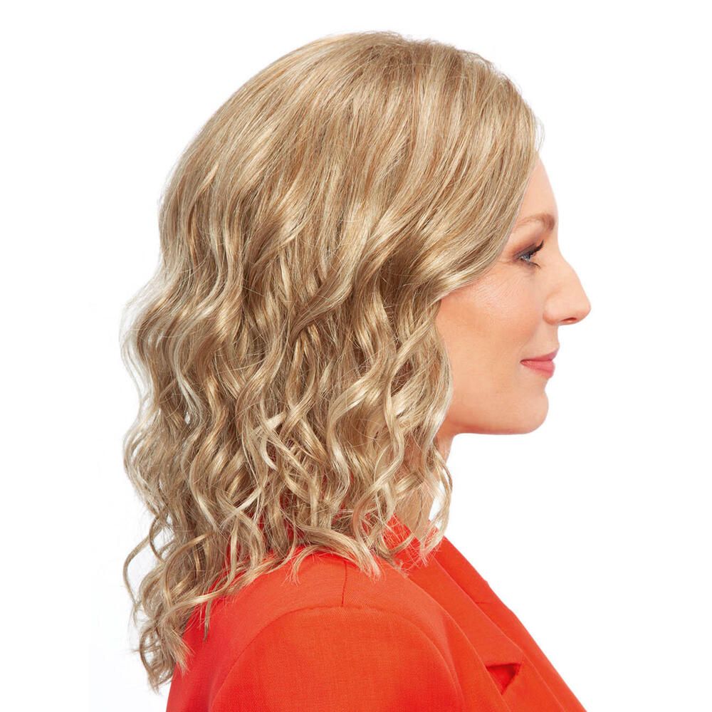 Blonde Perücke mit gewelltem Haar. Frau mit rotem Blazer. Seitenansicht.