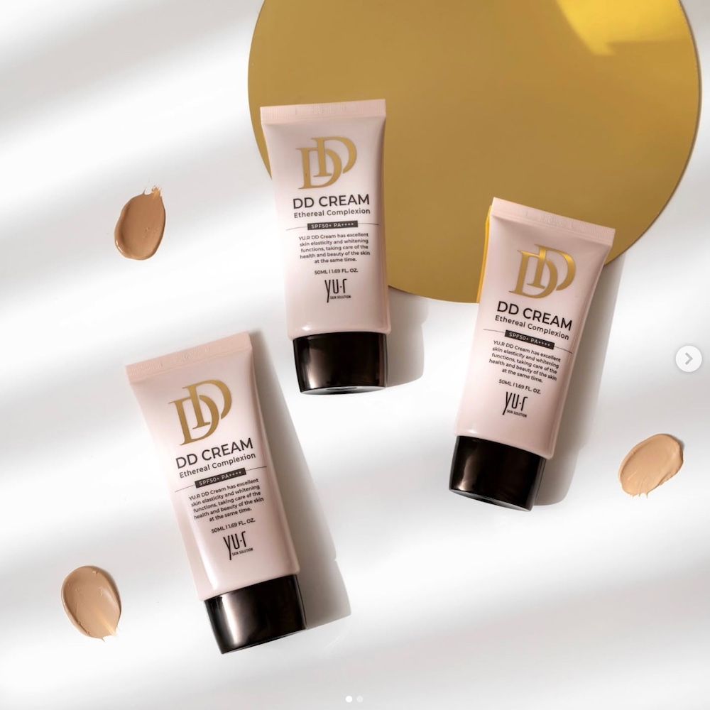 Drei rosa Tuben mit schwarzem Deckel. Aufschrift: DD CREAM Ethereal Complexion. Marke: Yu.r Skin Solution. Daneben drei Farbtupfer.