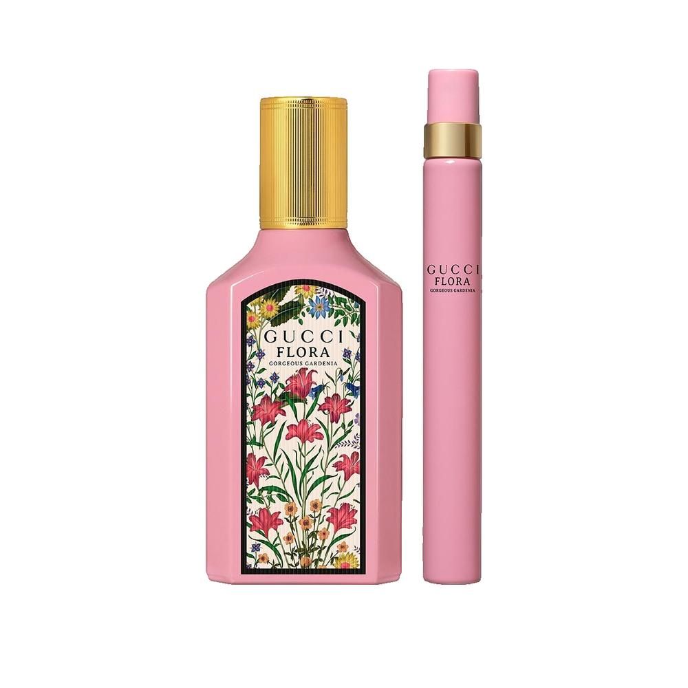 Pinkfarbene Flasche mit goldenem Deckel und floralem Etikett. Daneben ein pinkfarbener Zerstäuber mit goldener Schrift.