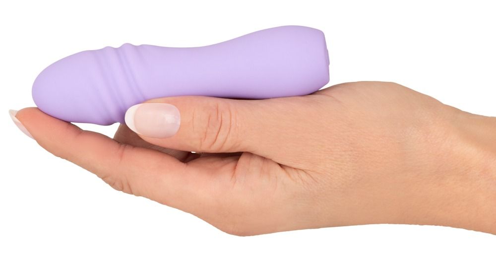 Lila Vibrator in Hand gehalten. Längliche Form, gewellte Oberfläche. Material: Silikon.