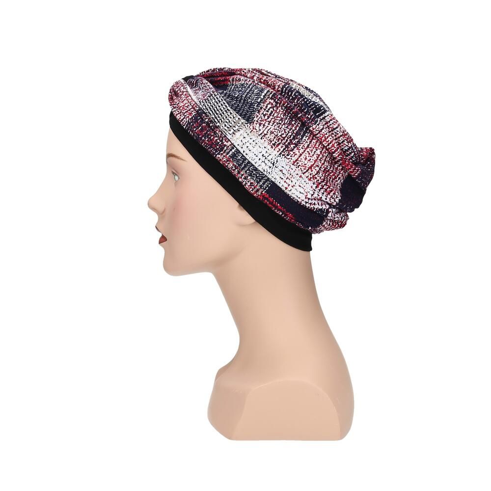 Turban mit mehrfarbigem Muster auf einem Schaufensterpuppenkopf. Schwarzes Stirnband. Seitenansicht.