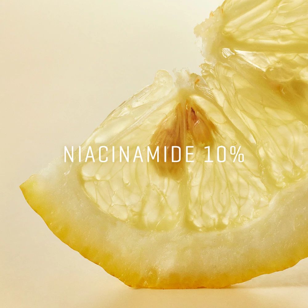 Zitronenscheibe mit der Aufschrift Niacinamid 10%.