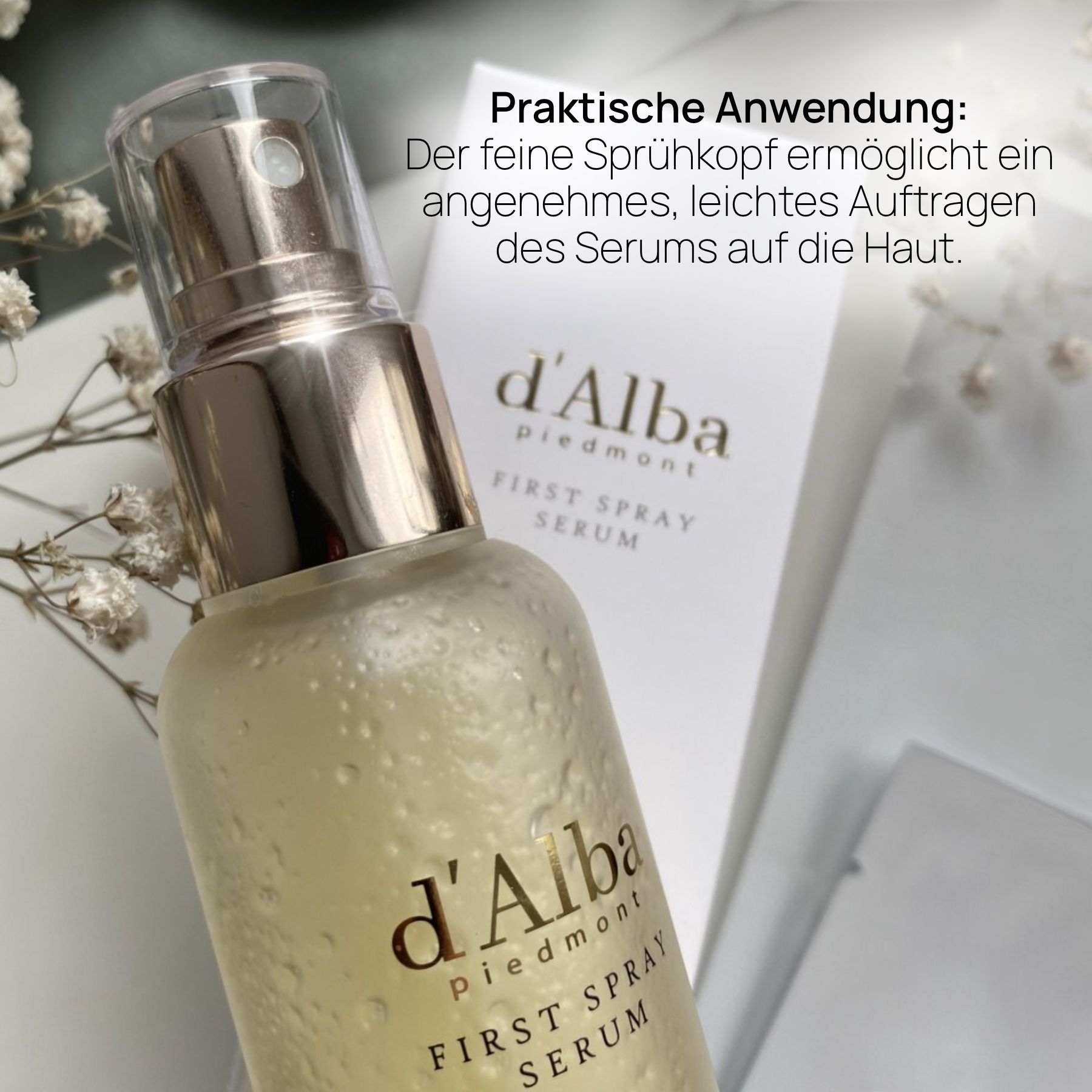 Produkt mit Sprühkopf und Verpackung. Text: d'Alba, First Spray Serum. Text: Praktische Anwendung: feiner Sprühkopf.