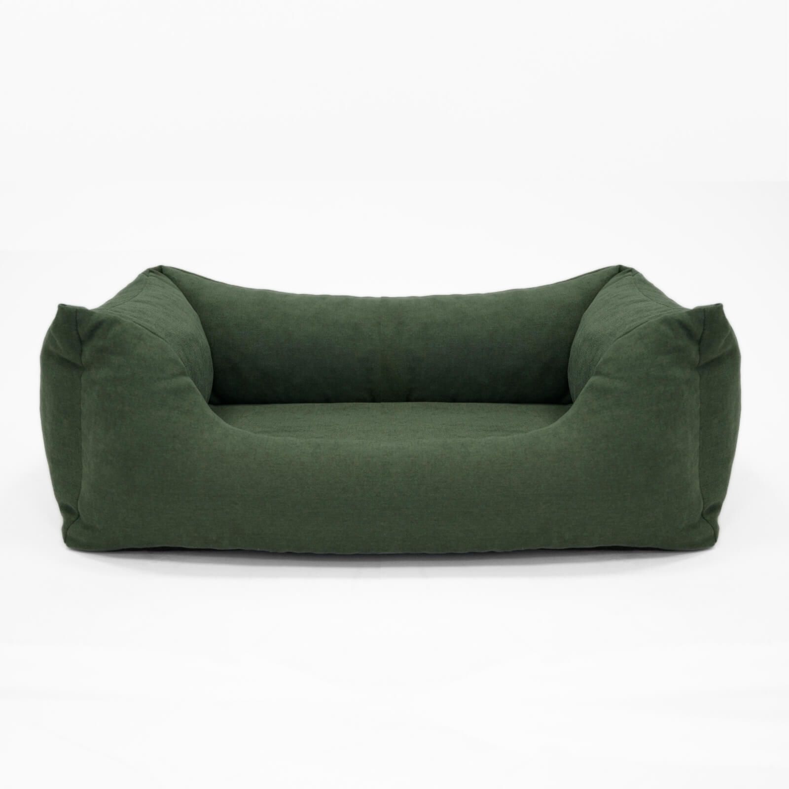 Grünes Hundebett mit erhöhten Seiten und niedriger Front. Rechteckige Form, weiches Material.