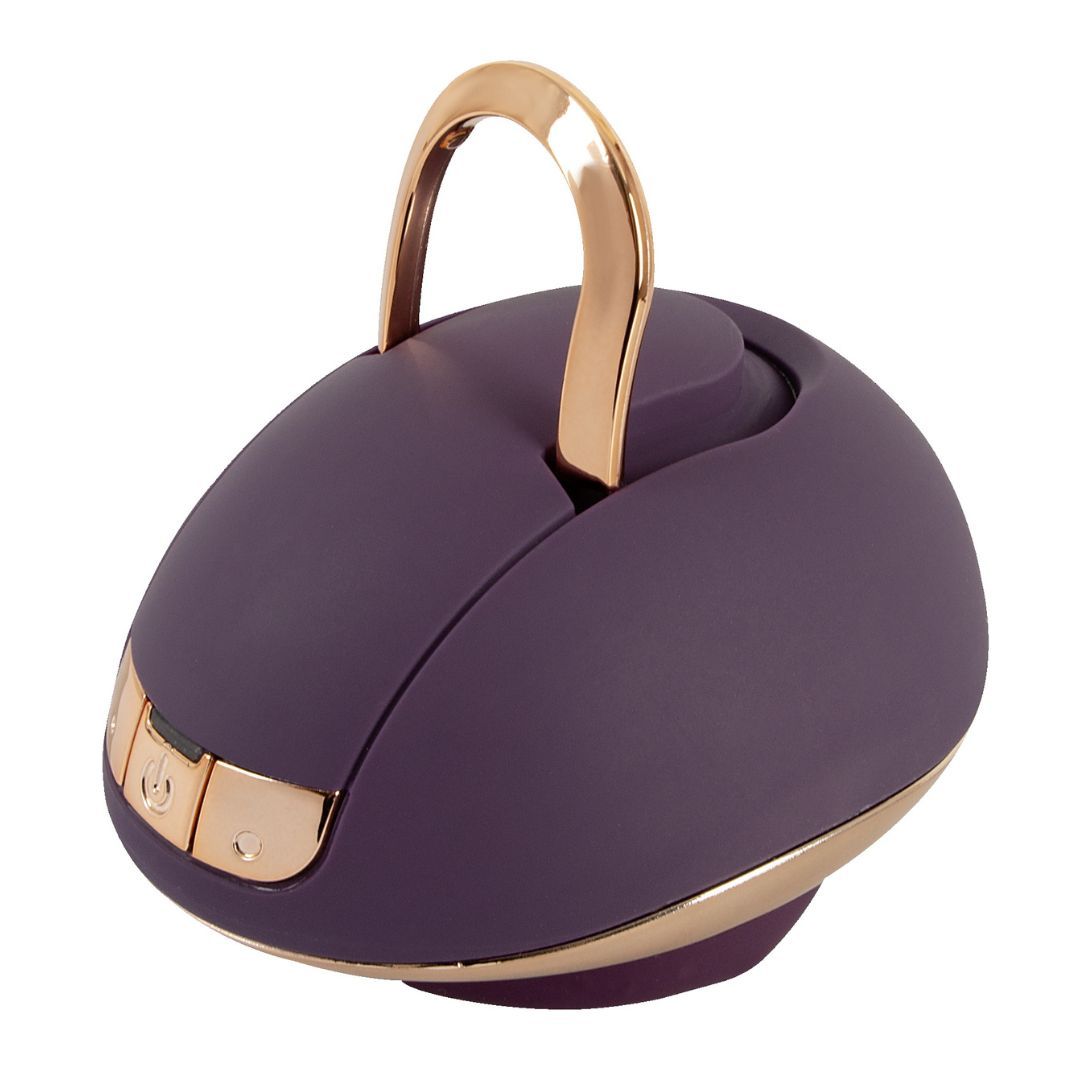 Lila-farbener Auflegevibrator mit goldfarbenen Akzenten und Griff. Runde Form mit Bedienfeld.