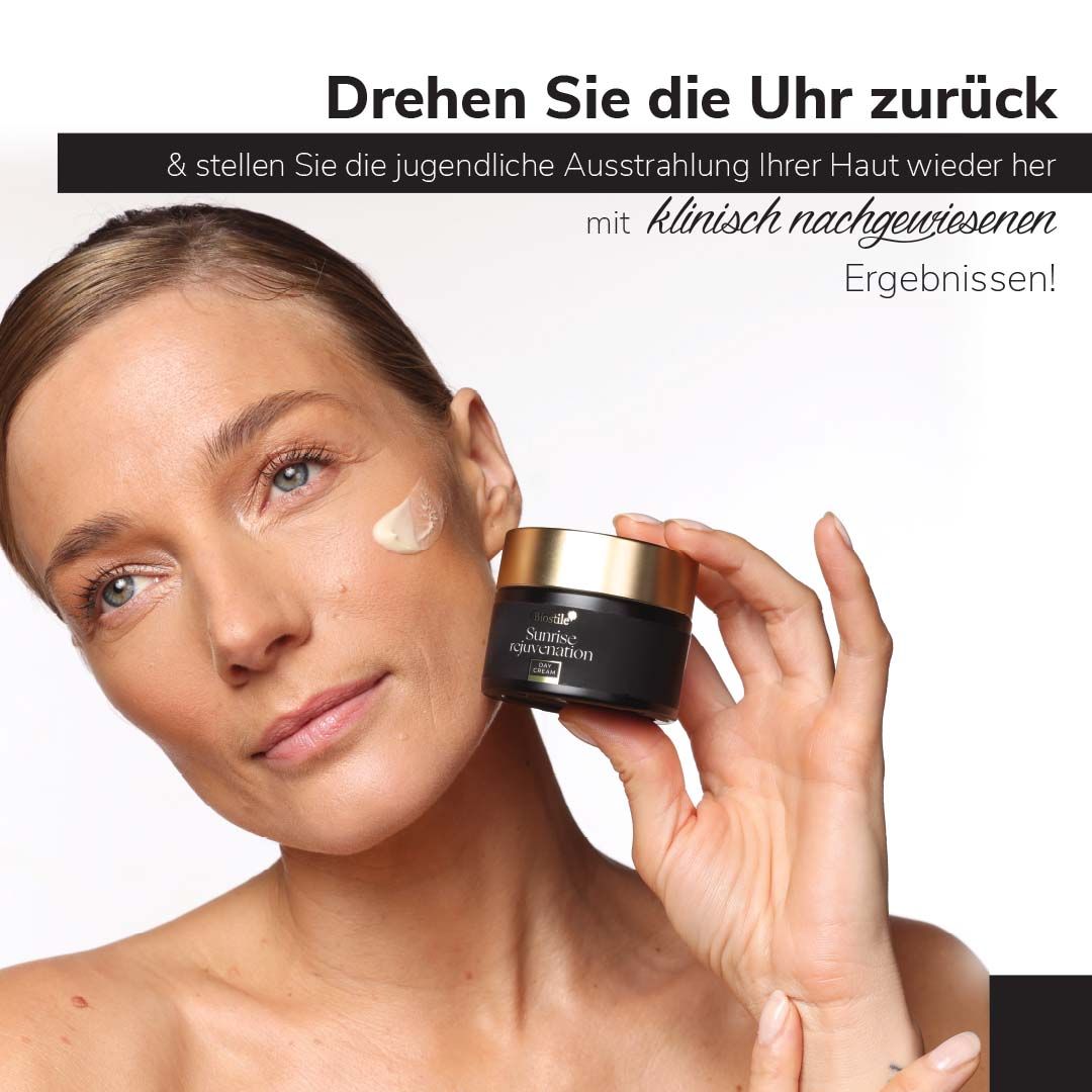 Frau hält Tiegel mit Biostile Sunrise Rejuvenation Day Cream. Auf Gesicht Creme aufgetragen.