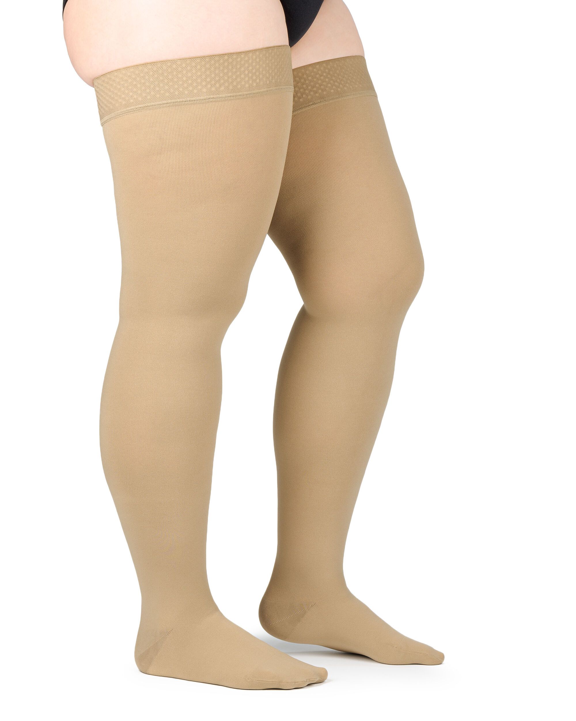 Beige Kompressions-Schenkelstrümpfe. Mit Haftband. Auf weißem Hintergrund. Blick von der Seite.