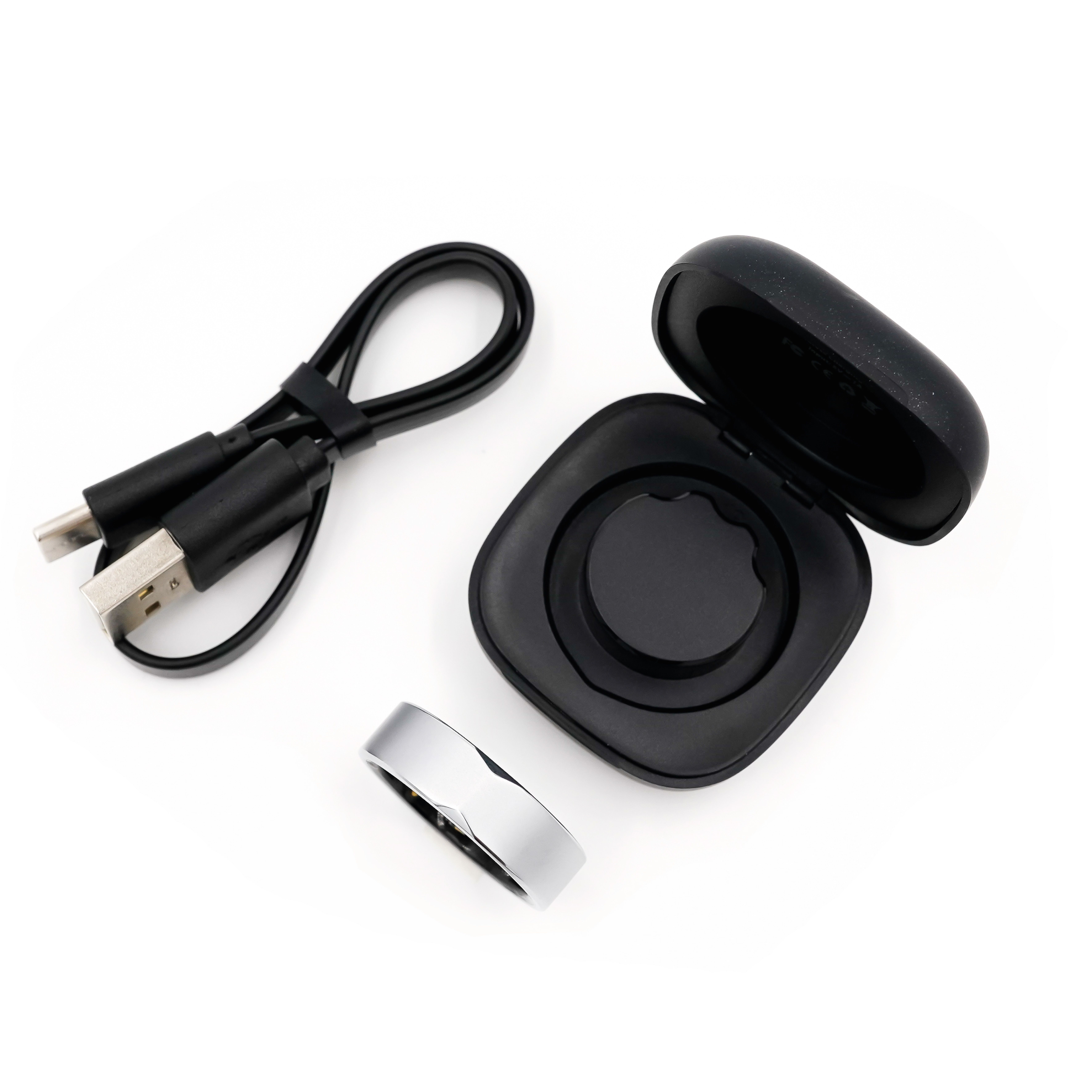 Ring, Ladebox, Ladekabel. Ring silberfarben. Box und Kabel schwarz.