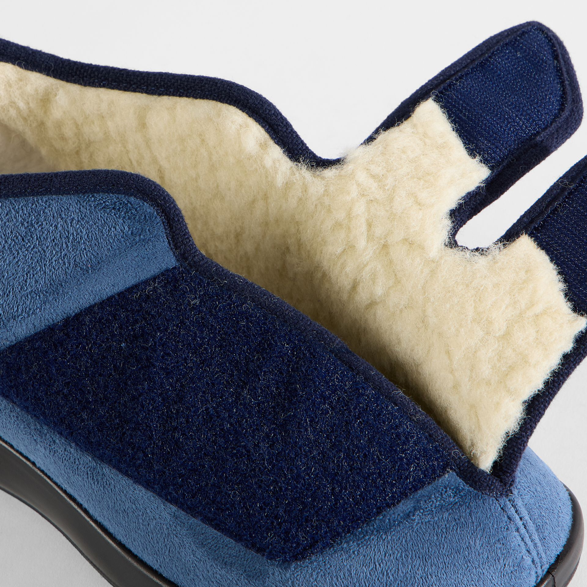 Dunkelblaue Hausschuhe mit Klettverschluss und weichem Futter.
