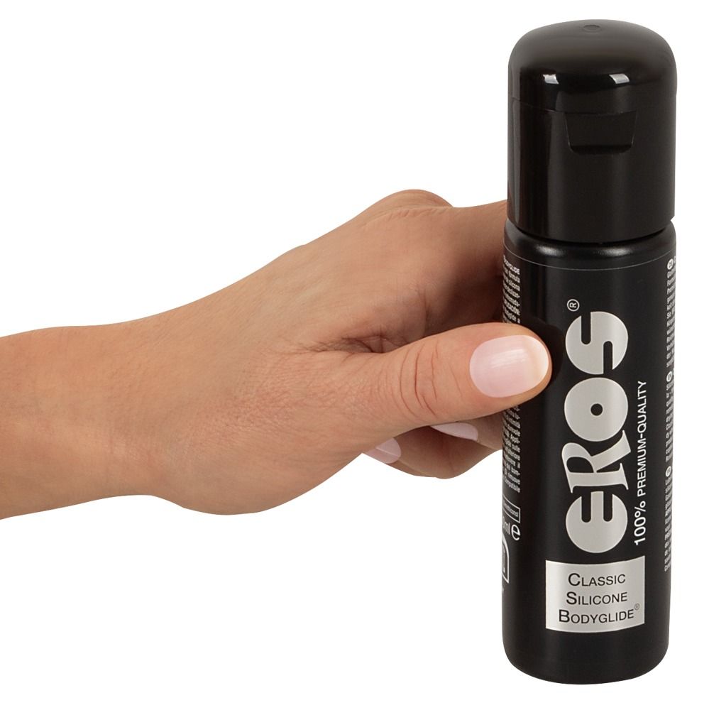 Hand hält eine schwarze Flasche mit schwarzem Deckel. Eros-Logo und Schriftzug „Classic Silicone Bodyglide“.
