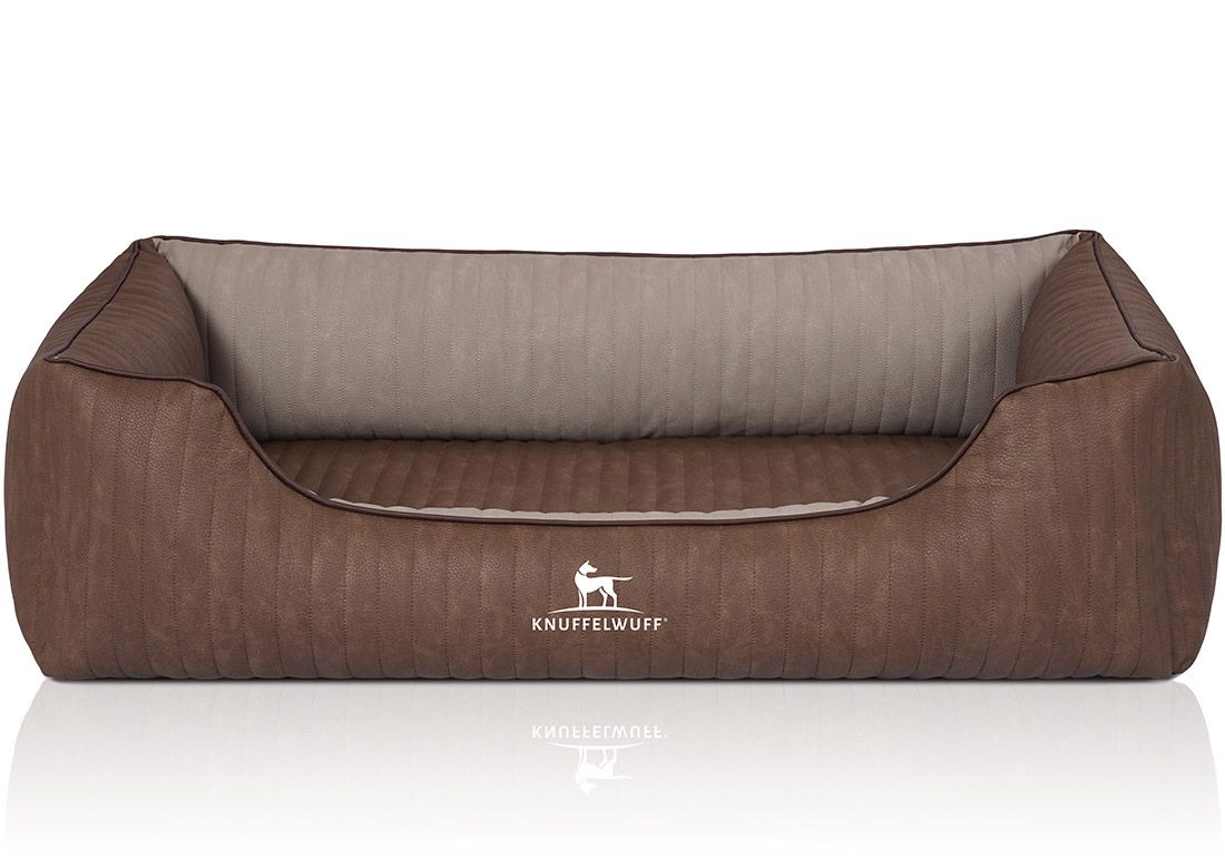 Braunes Hundebett mit beigem Innenraum. Gepolstert, mit dem Logo Knuffelwuff. Rechteckige Form mit abgerundeten Ecken.