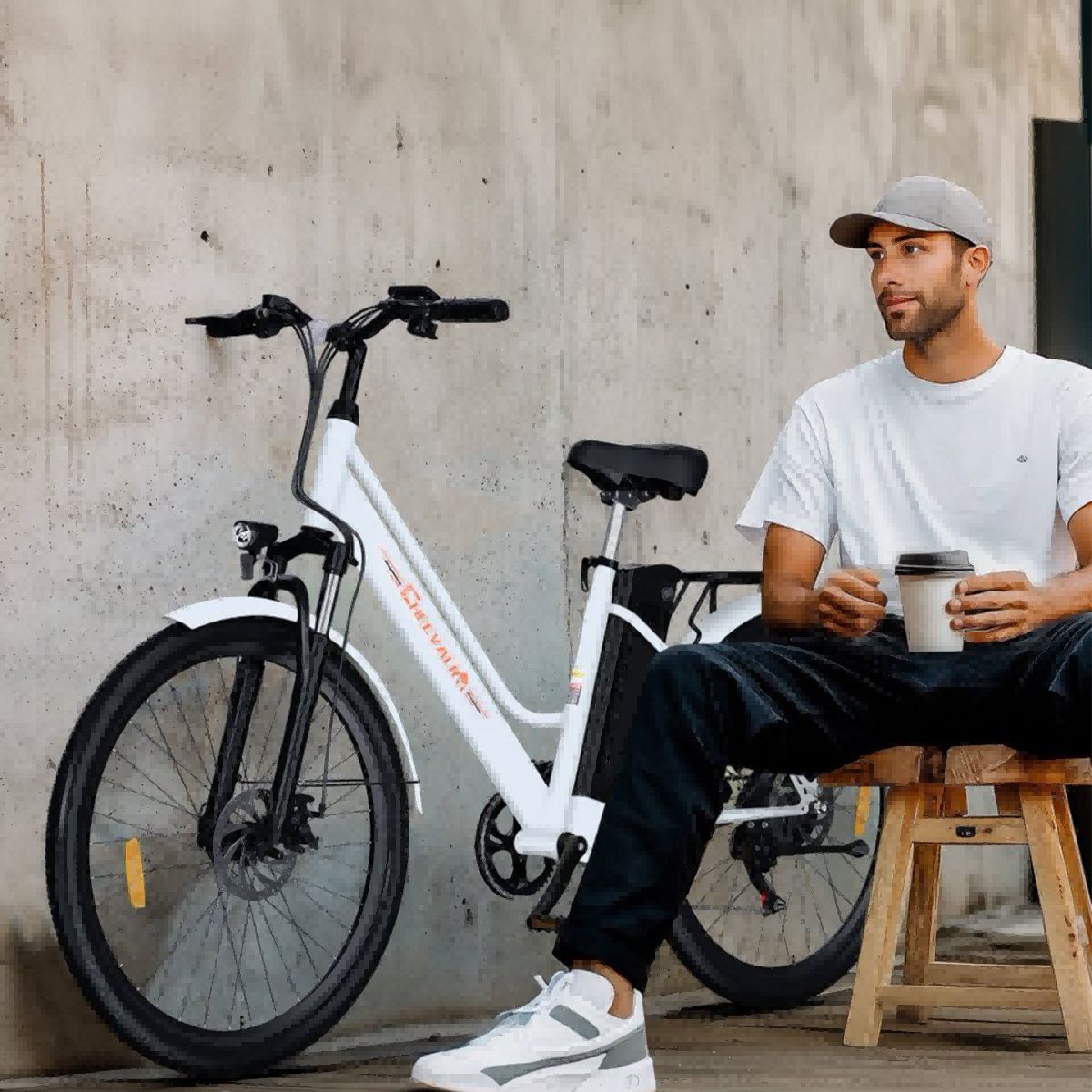 Mann sitzt neben weißem Elektrofahrrad. Marke Cheevalry.