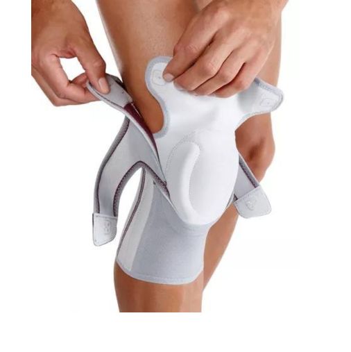 Person hält Kniebandage. Grau-weiß mit Push-Logo. Klettverschlüsse. Innen rot. Blickwinkel: Nahaufnahme.