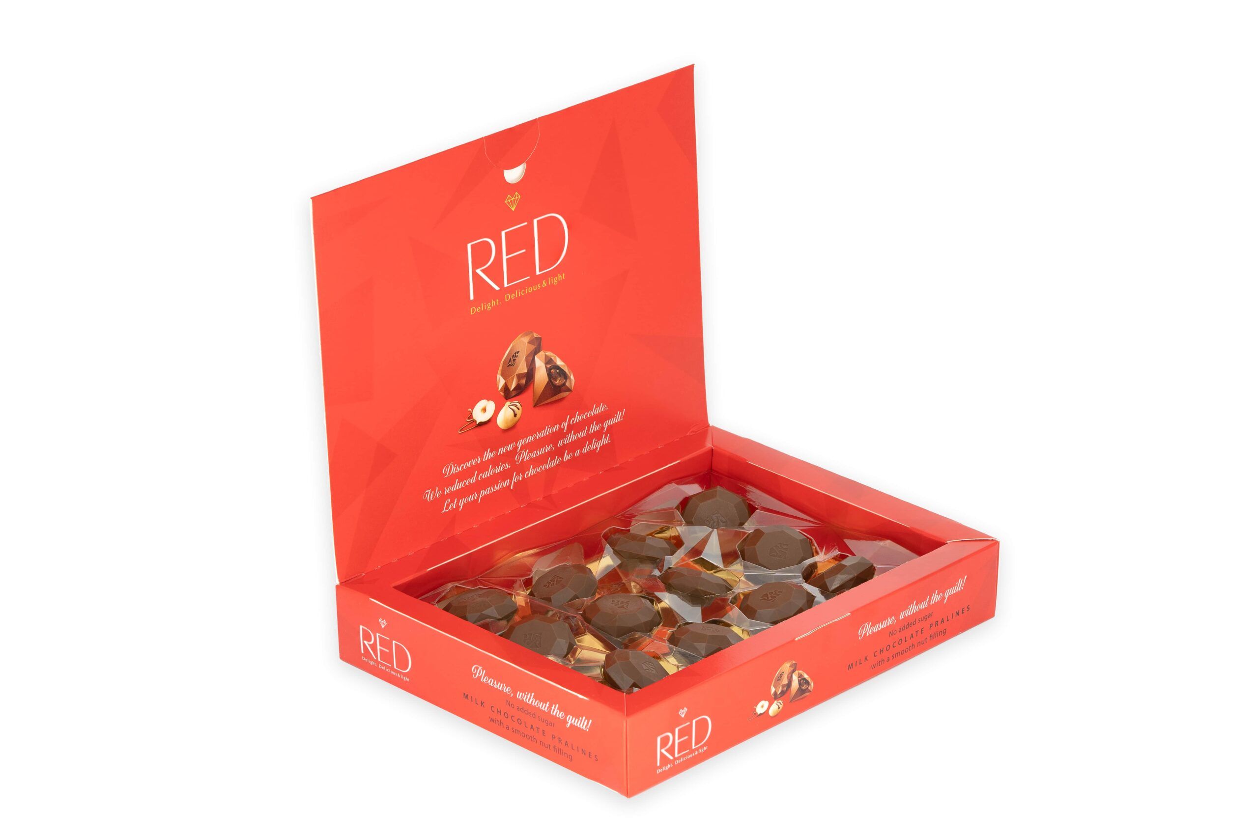 Geöffnete rote Schachtel mit Pralinen. Aufschrift "RED". Pralinen mit Haselnussfüllung sichtbar. Text: "Pleasure, without the guilt!".