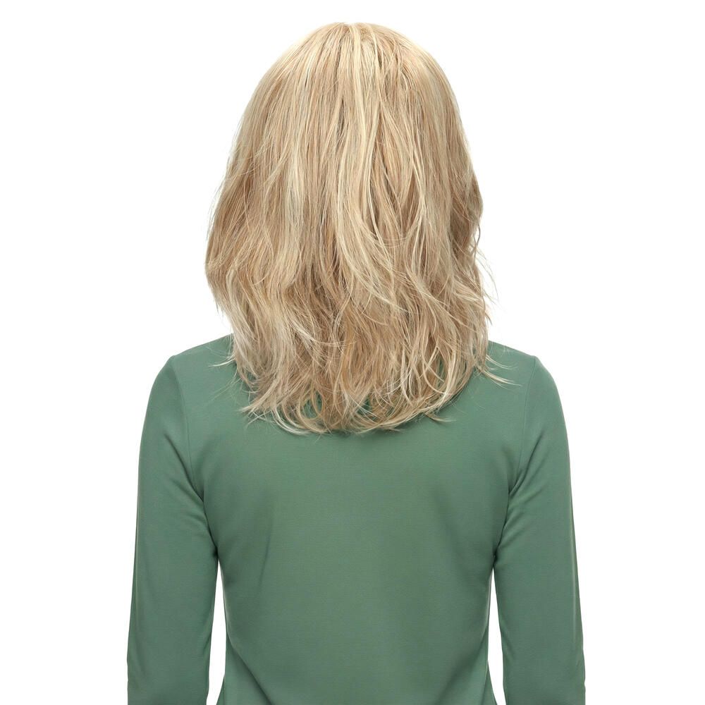 Rückansicht einer blonden, gewellten Perücke. Die Haare fallen bis zu den Schultern. Trägerin in grünem Oberteil.