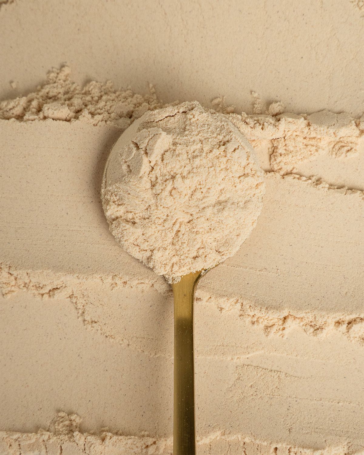 Goldener Löffel mit Bio Baobab Pulver, Nahaufnahme.