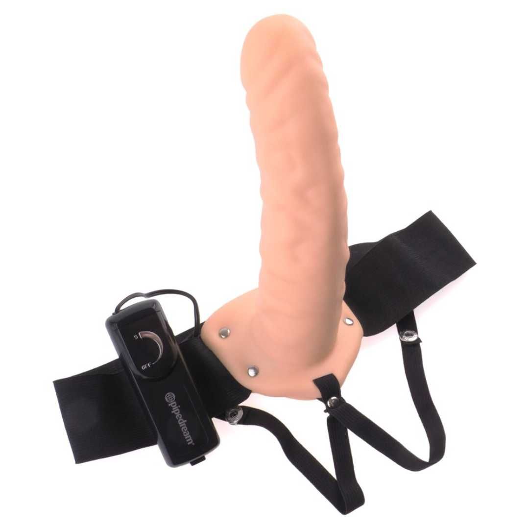 Beigefarbener Dildo mit schwarzem Harness und Vibrationssteuerung. Aufschrift 'pipedream'.