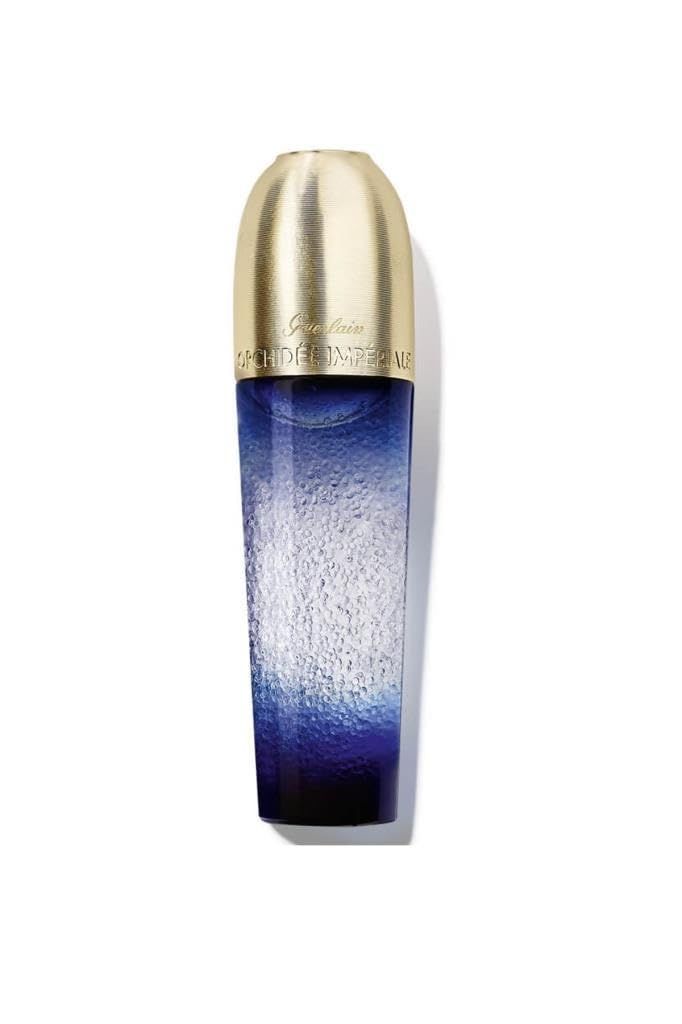 Blau-transparente Flasche mit goldfarbenem Deckel. Aufschrift: Guerlain Orchidée Impériale. Vertikale Ansicht.