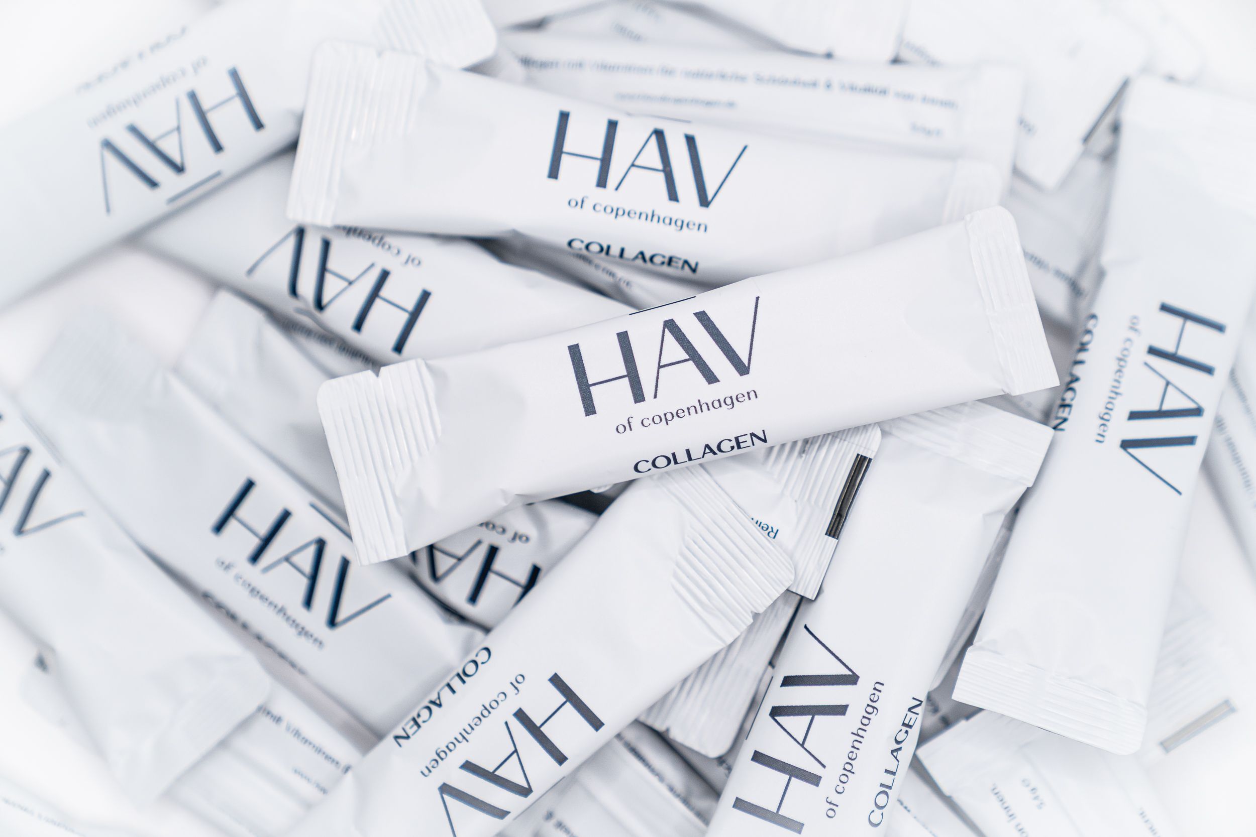 Haufen von weißen Collagen-Sticks mit HAV-Logo und Schriftzug.
